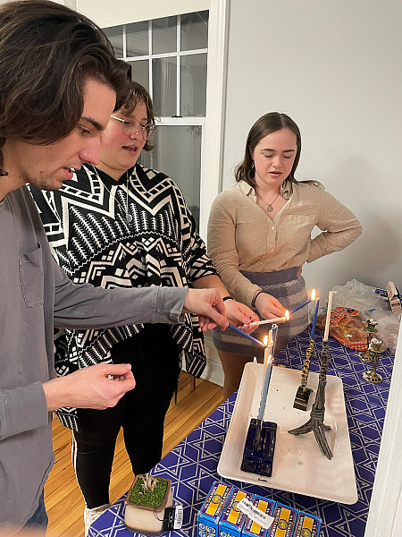 Hillel Students lighting holiday Hanukah candles.