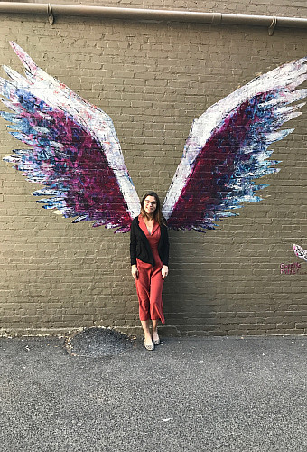 Alexandra Nigro standing in front of street art