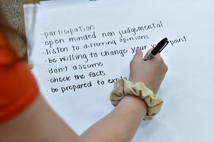Student writing affirmations on a whiteboard.