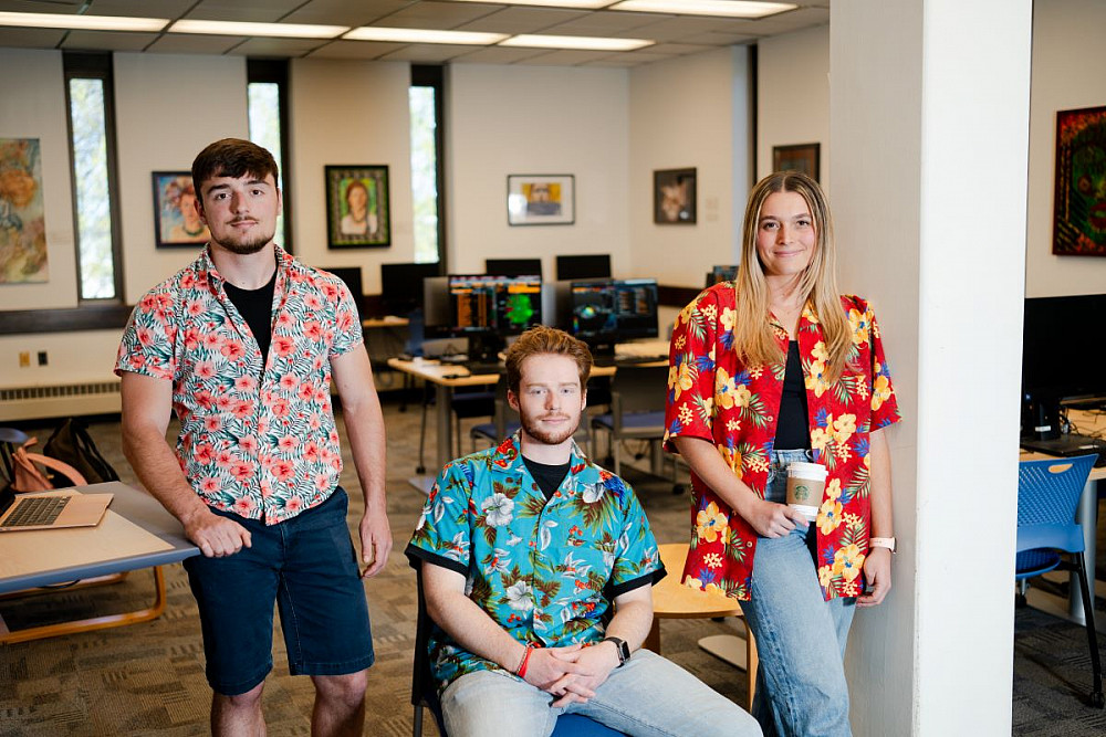 From l-r, Kieran MacDonough ’24, Evan Coffey ’24, and Kaela Frenchman ’24 don Hawaiian shirts to honor their late professor,Scott Deacle.