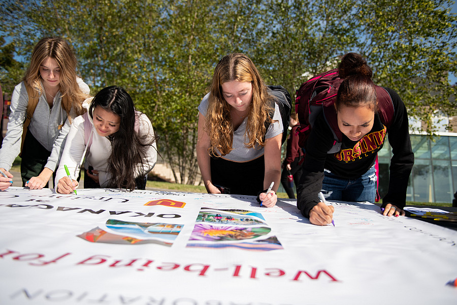 Students, faculty, and staff ceremoniously signed a banner signifying their own wellness commitment the inauguration luncheon, where Pres...