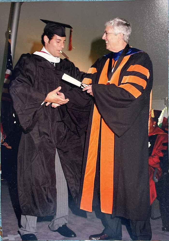 Eduardo Ramos receiving his diploma from John Strassburger