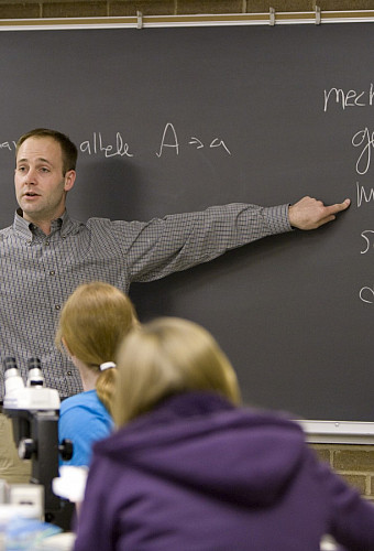 Photo of Cory Straub teaching in front of a chalkboard