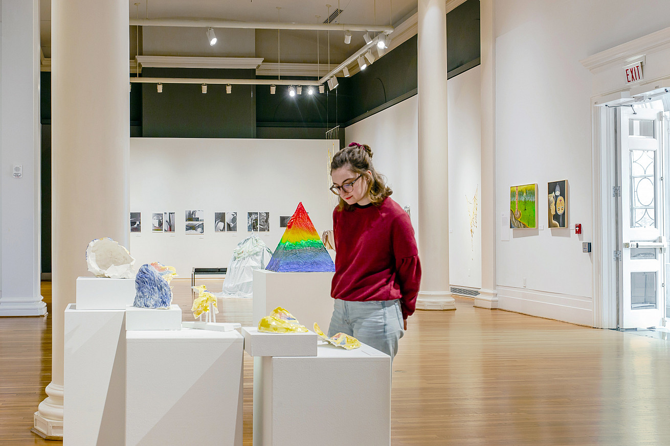 Student gazing at sculptures in Main Gallery of Berman Museum.