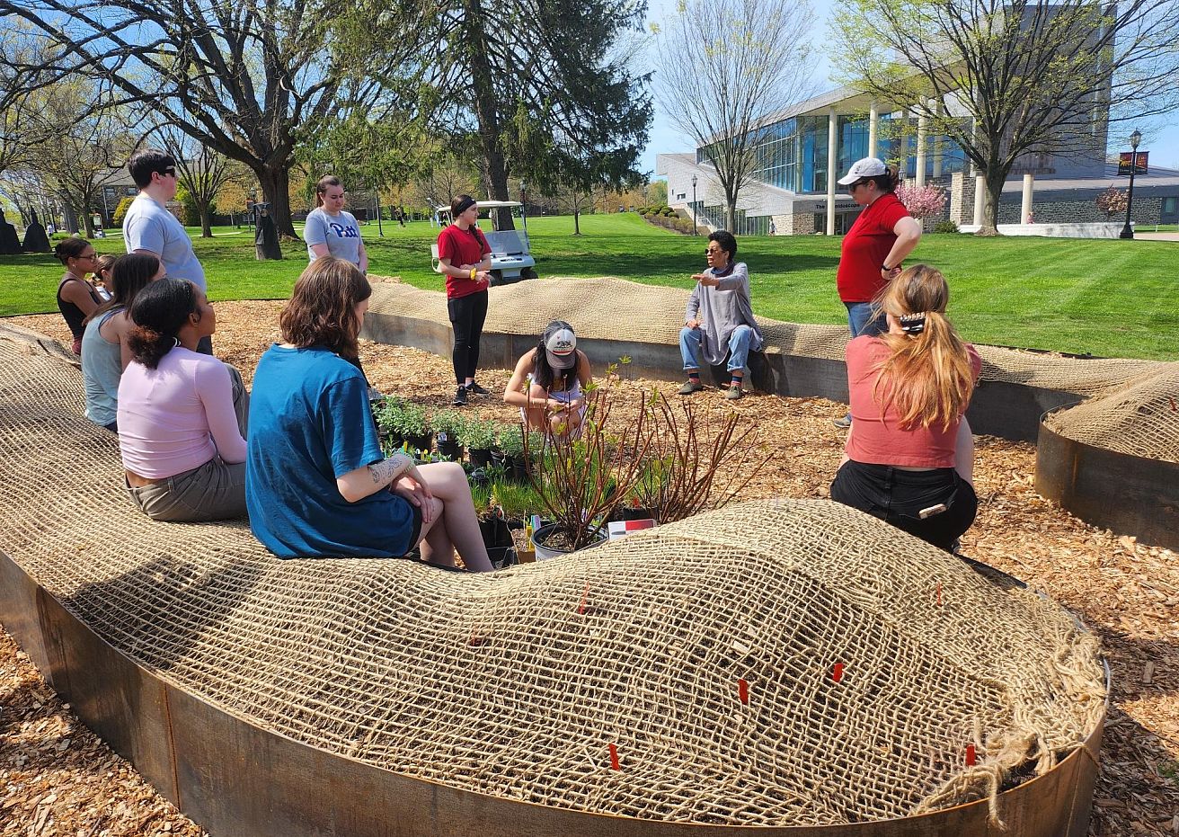 Syd Carpenter with BIO 334 students at the hügel site to prepare and organize the garden's plants.