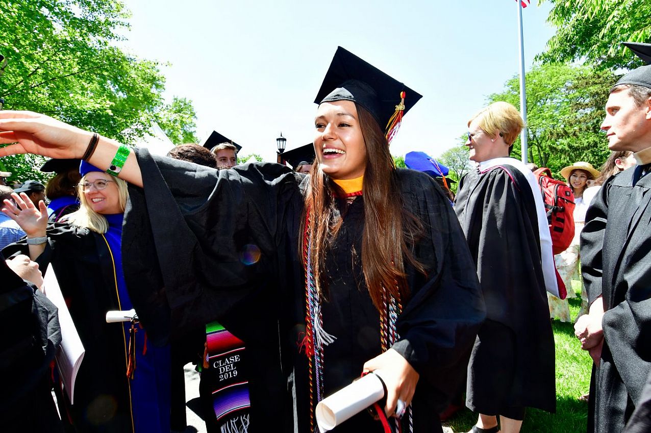 Students outside gathering after their graduation ceremony.