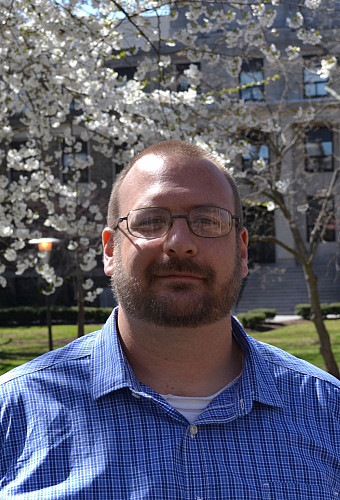 Tristan Ashcroft standing in front of a blossoming tree
