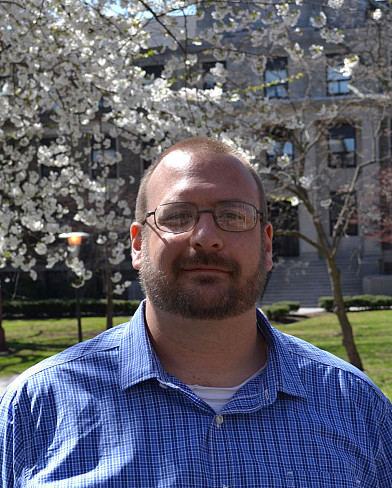 Tristan Ashcroft standing in front of a blossoming tree