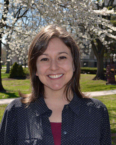 Leah Joseph standing in front of a blossoming tree