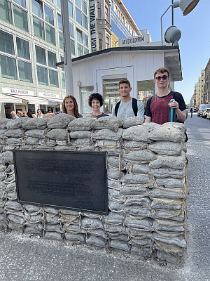 Standing at the historic Checkpoint Charlie, a symbol of the Cold War era and Berlin's divided past.