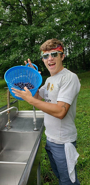 2019 Farm Fellow Brandon Slaboda (Class of '22) showing off some of our blueberries, one of our most popular crops.