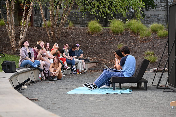Students gathered together outside talking with one another.