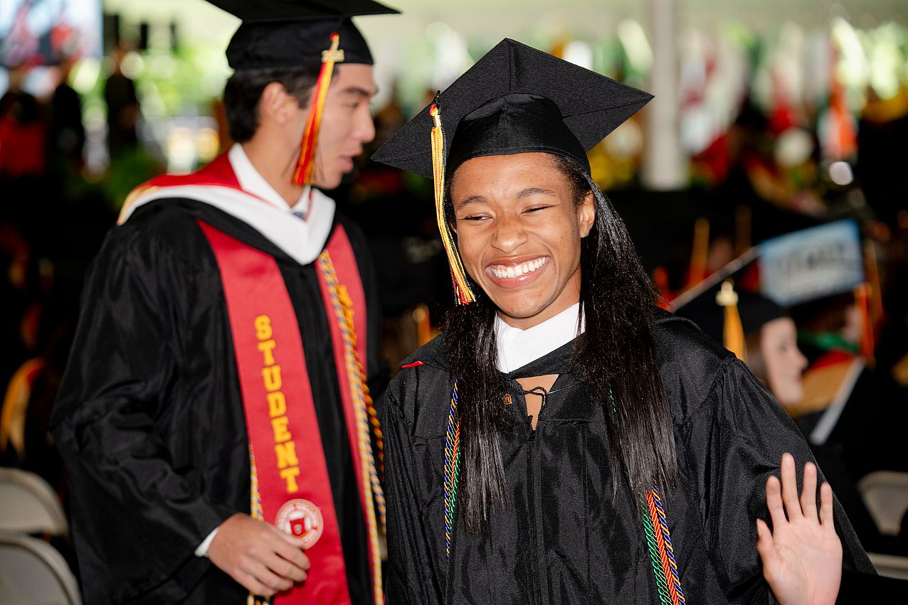 Student smiling at 2024 commencement candid