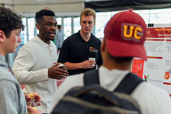 Students talking holding cups and bottled beverages.